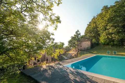 Vallorsaia’s pool beside stone steps and terraces among the trees